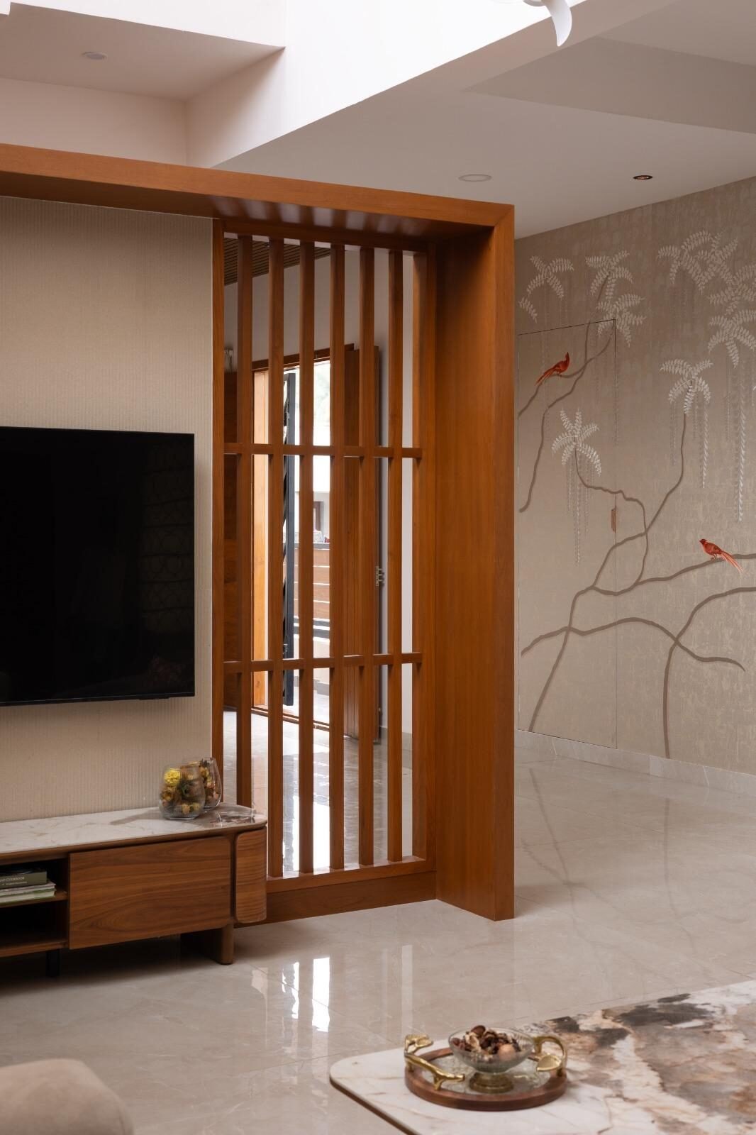 Teak wood wardrobe and mirror beside a chinoiserie-papered entry wall