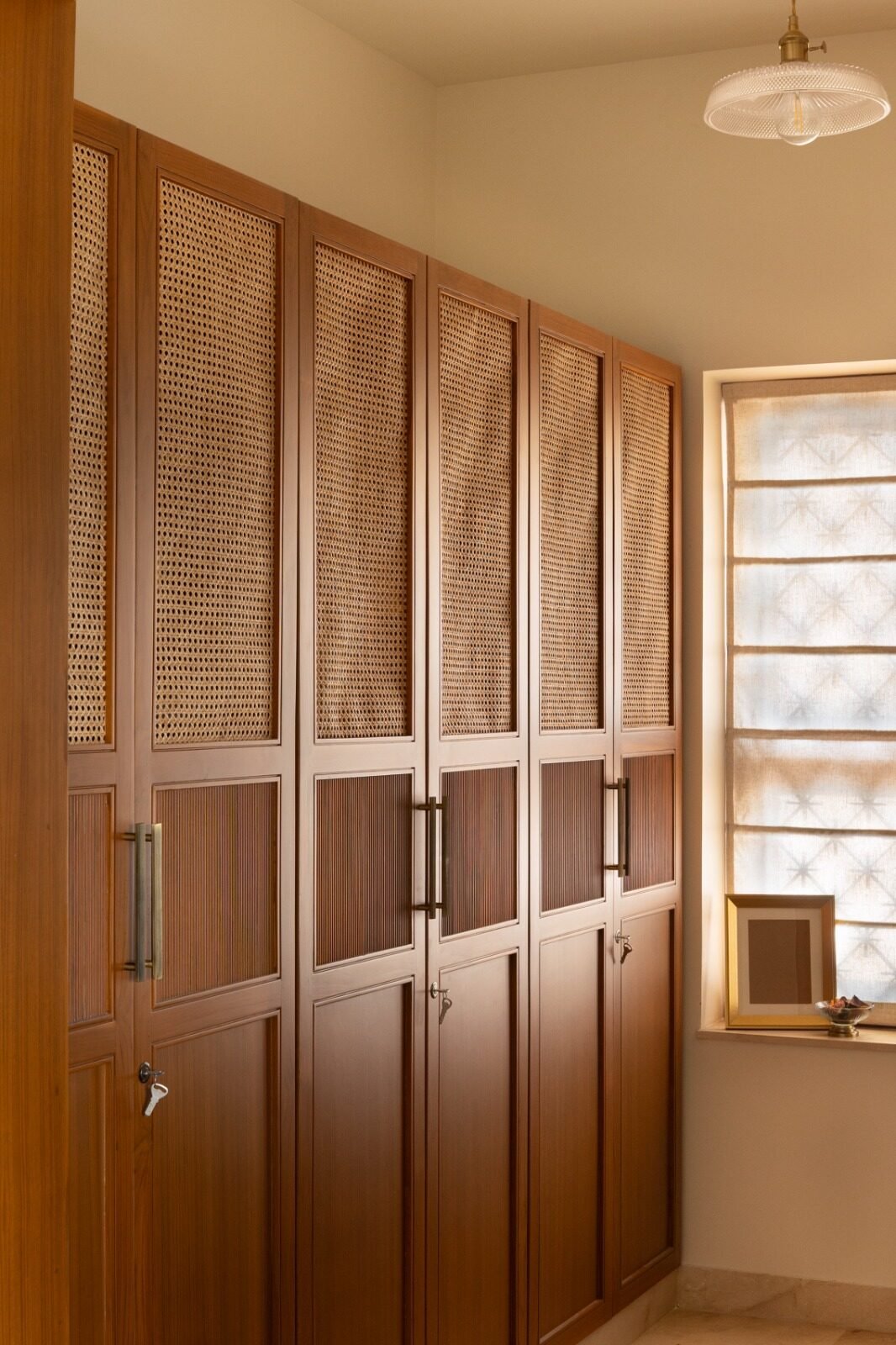 Wardrobe wall finished with woven mesh panel doors